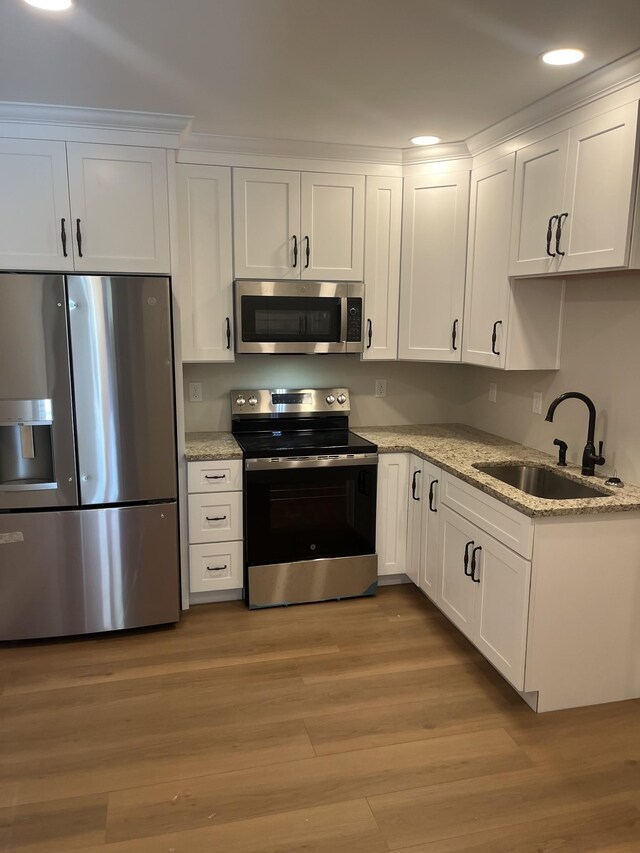 1168 N Franklin Ave, Cookeville, TN 38501 - kitchen featuring appliances with stainless steel finishes, a sink, white cabinetry, recessed lighting, and light wood finished floors