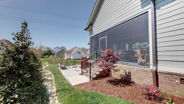 view of yard featuring a sunroom, a residential view, a patio area, and fence
