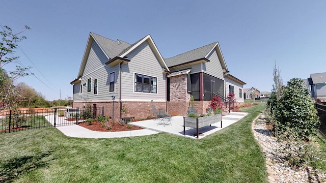 view of side of home with brick siding, fence, a lawn, and a patio area
