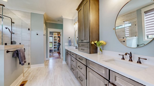 bathroom with a sink, ornamental molding, a walk in closet, a shower stall, and double vanity