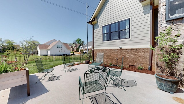 view of patio featuring fence, a residential view, and outdoor dining area