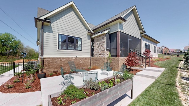 bungalow-style house featuring a patio, brick siding, stone siding, fence, and a front lawn