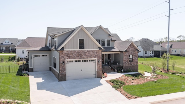 craftsman-style house featuring board and batten siding, driveway, fence, and a front lawn