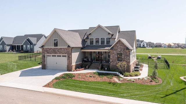 craftsman-style house with fence, a front yard, board and batten siding, and stone siding