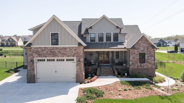 craftsman house featuring covered porch, a front yard, an attached garage, french doors, and concrete driveway
