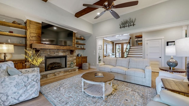 living room with baseboards, a fireplace, stairs, ceiling fan, and wood finished floors