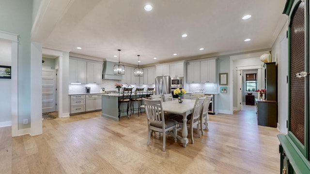 dining area featuring light wood-style flooring, crown molding, baseboards, and recessed lighting