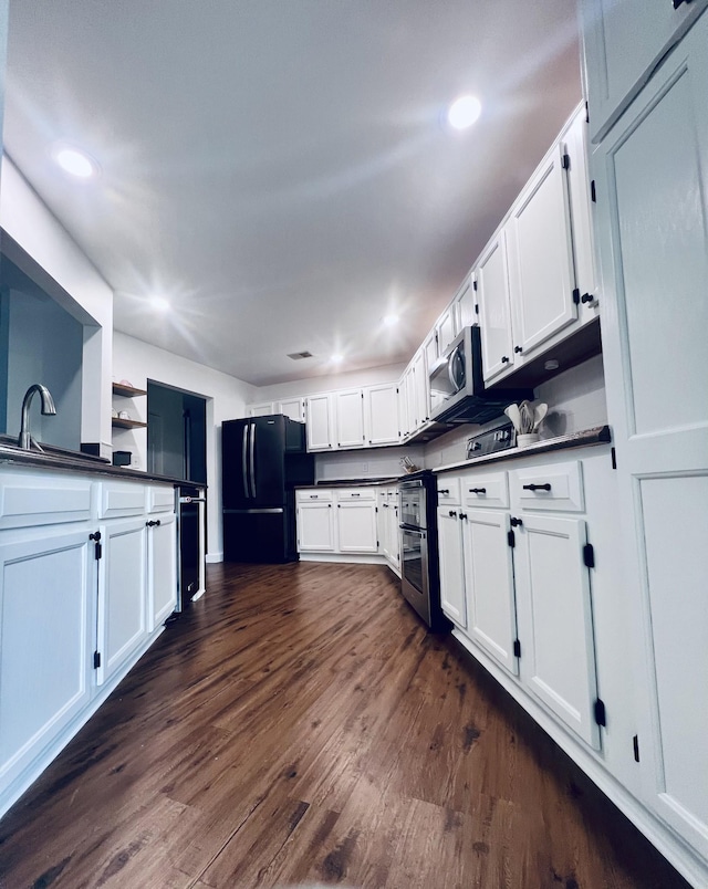 1046 Huntsman Cir, Franklin, TN 37064 - kitchen with freestanding refrigerator, dark countertops, white cabinets, recessed lighting, and stainless steel microwave