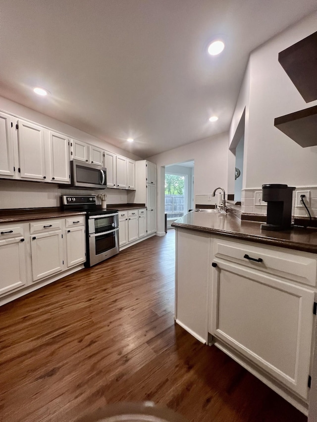 1046 Huntsman Cir, Franklin, TN 37064 - kitchen with appliances with stainless steel finishes, dark countertops, dark wood-style floors, white cabinetry, and recessed lighting
