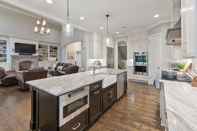 6685 Hastings Ln, Franklin, TN 37069 - kitchen featuring open floor plan, arched walkways, appliances with stainless steel finishes, and a sink