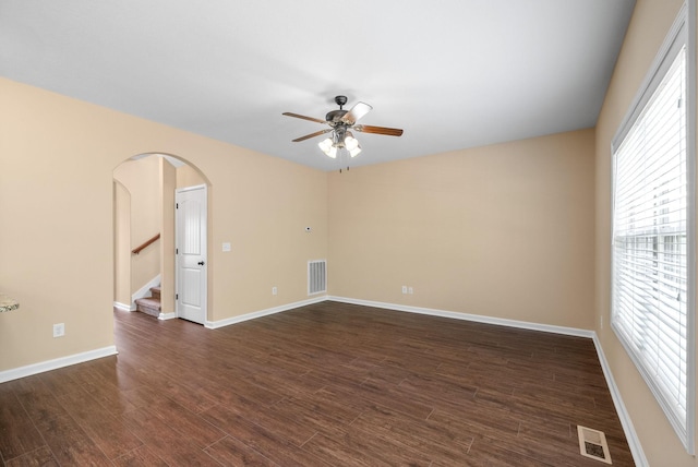 1313 Allmon Dr, Clarksville, TN 37042 - unfurnished room featuring a ceiling fan, arched walkways, stairs, dark wood-style floors, and baseboards