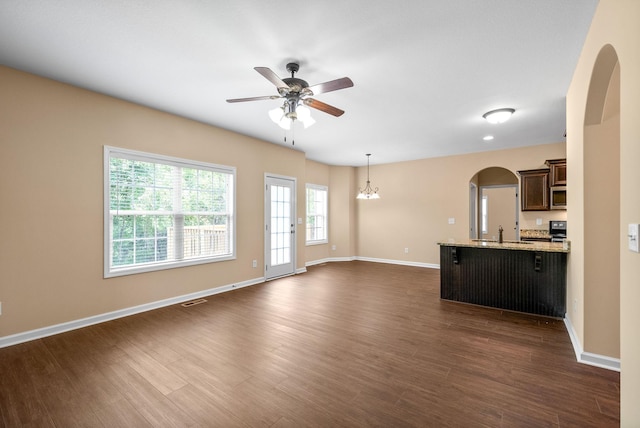 1313 Allmon Dr, Clarksville, TN 37042 - unfurnished living room with ceiling fan, dark wood finished floors, arched walkways, and a chandelier