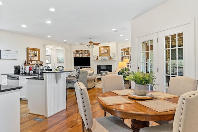 175 Southern Woods Ct, Cookeville, TN 38506 - dining space with a glass covered fireplace, recessed lighting, a ceiling fan, light wood-style floors, and arched walkways