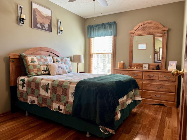 bedroom featuring ceiling fan, a textured ceiling, and wood finished floors