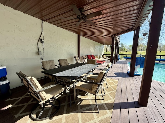 deck featuring an outdoor pool, outdoor dining space, and a ceiling fan