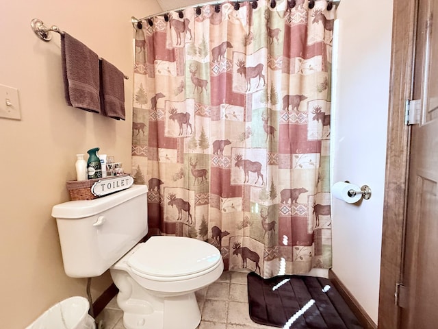 full bathroom with toilet, a shower with curtain, baseboards, and tile patterned flooring