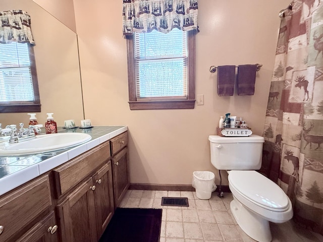 bathroom featuring visible vents, baseboards, toilet, and a healthy amount of sunlight