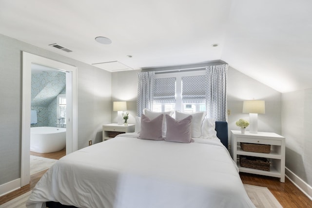 4610 Elkins Ave, Nashville, TN 37209 - bedroom featuring wood finished floors, vaulted ceiling, baseboards, and ensuite bathroom