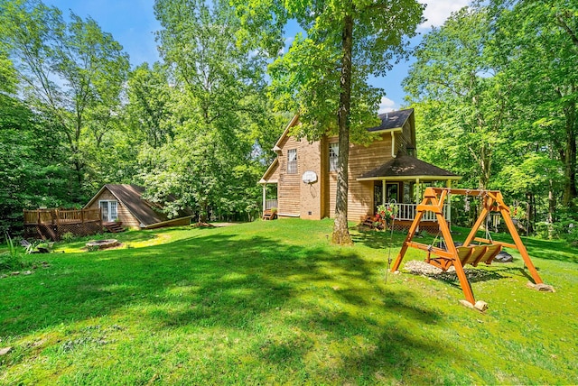 4862 Louise Rd, Cumberland Furnace, TN 37051 - view of green lawn featuring a fire pit, a playground, and a wooden deck