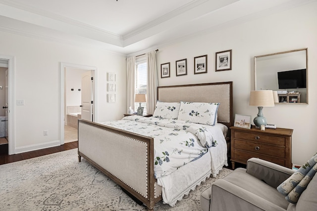 bedroom featuring baseboards, crown molding, connected bathroom, a raised ceiling, and wood finished floors