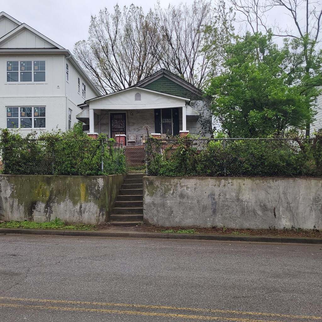 view of front of property featuring covered porch and stairway