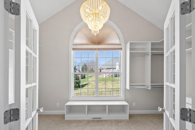 spacious closet with vaulted ceiling, a chandelier, french doors, visible vents, and carpet