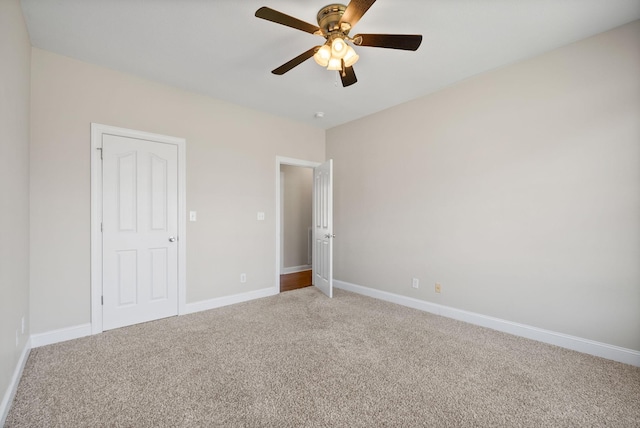 unfurnished bedroom featuring light carpet, baseboards, and a ceiling fan
