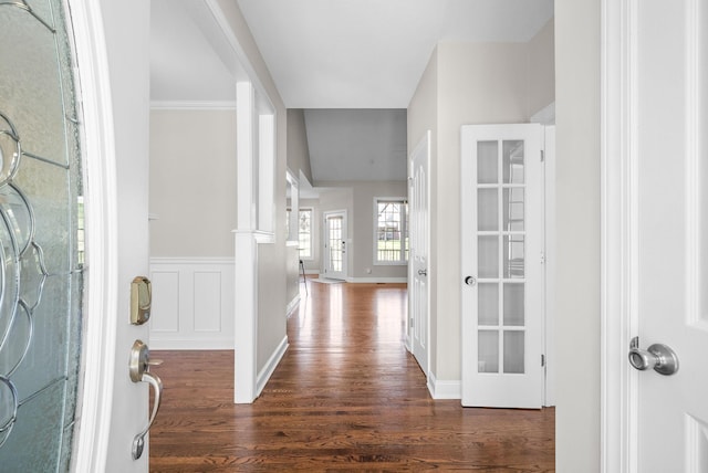 foyer with a wainscoted wall and dark wood finished floors