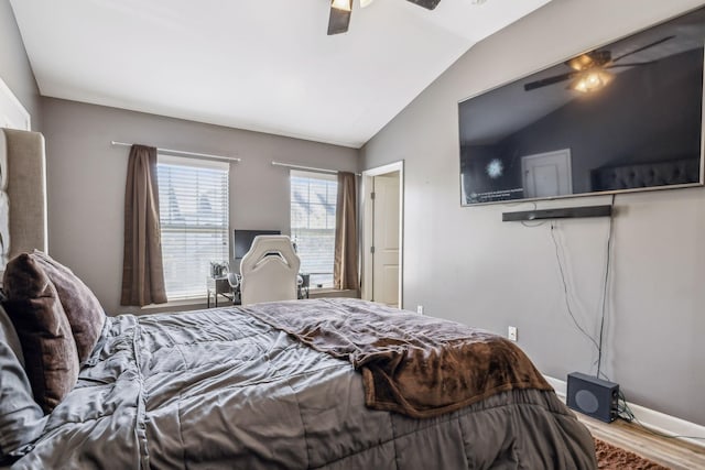 bedroom with ceiling fan, vaulted ceiling, and wood finished floors