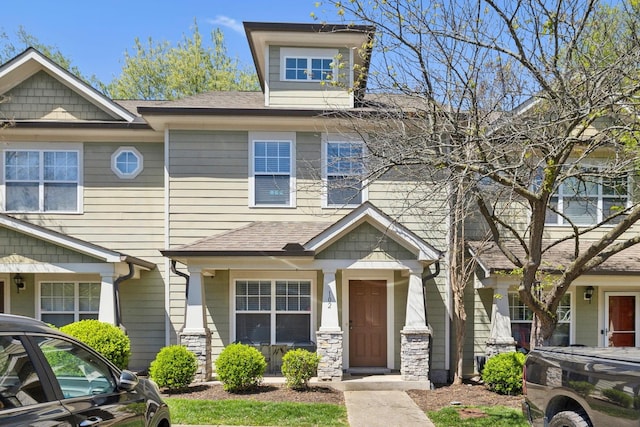 view of front of house with stone siding and a shingled roof