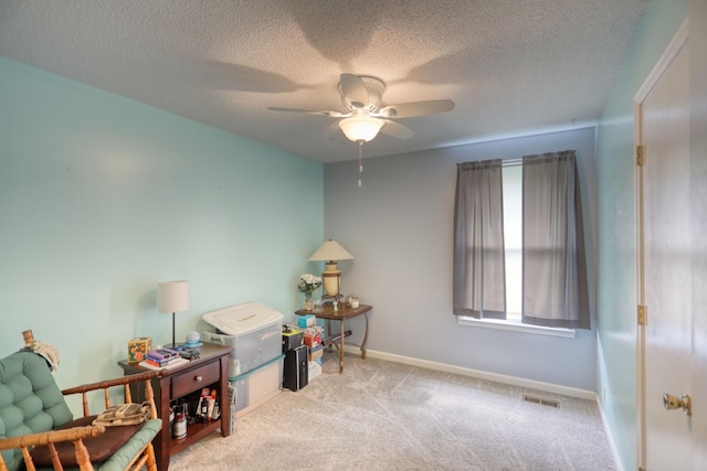 interior space featuring visible vents, baseboards, a ceiling fan, carpet, and a textured ceiling