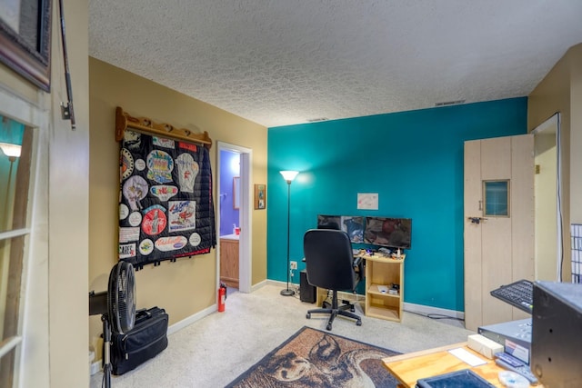 office with carpet, visible vents, a textured ceiling, and baseboards
