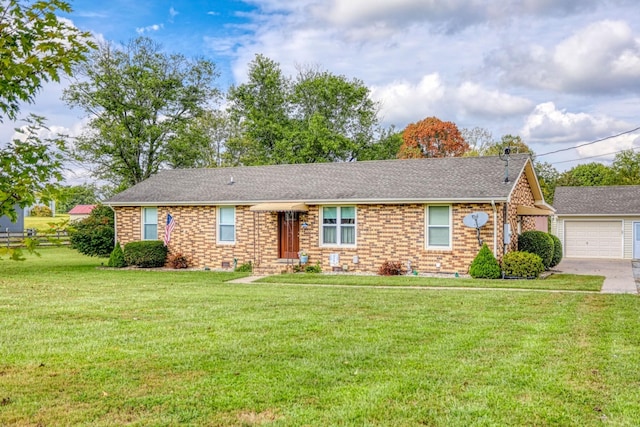 ranch-style house with driveway, a front lawn, brick siding, an outbuilding, and a garage