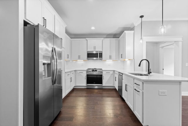 kitchen with a sink, appliances with stainless steel finishes, a peninsula, dark wood finished floors, and decorative backsplash