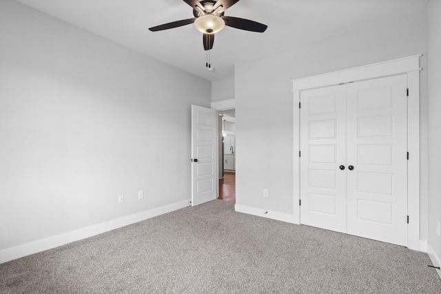 unfurnished bedroom featuring a closet, baseboards, a ceiling fan, and carpet floors