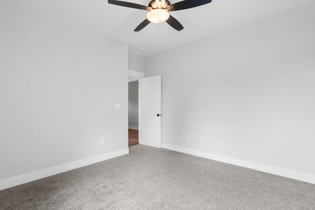 carpeted empty room with baseboards and a ceiling fan