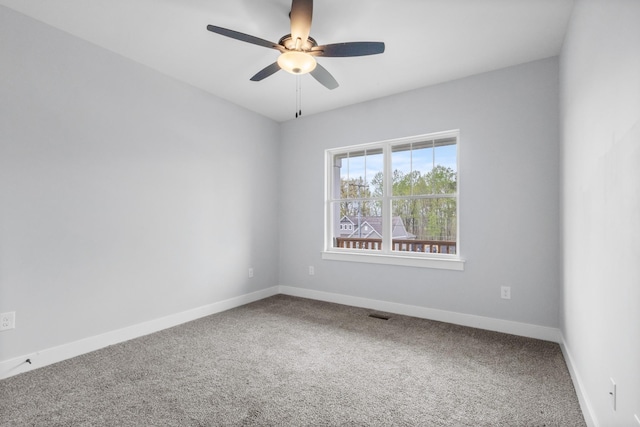 empty room with visible vents, carpet floors, ceiling fan, and baseboards