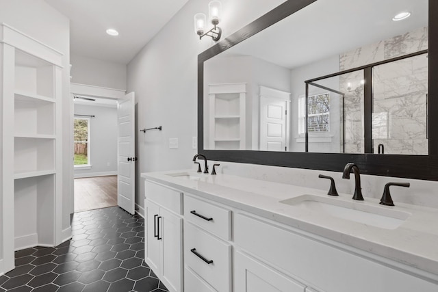 full bath with a sink, double vanity, a stall shower, and recessed lighting
