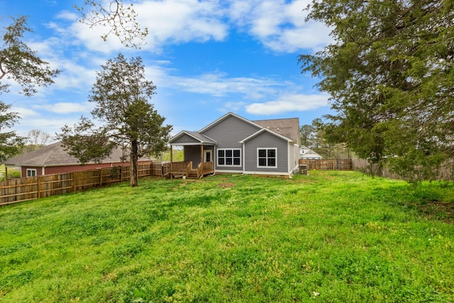 back of house with a yard, a fenced backyard, and a deck