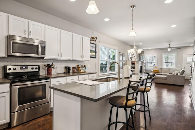 kitchen with recessed lighting, dark countertops, appliances with stainless steel finishes, and a sink