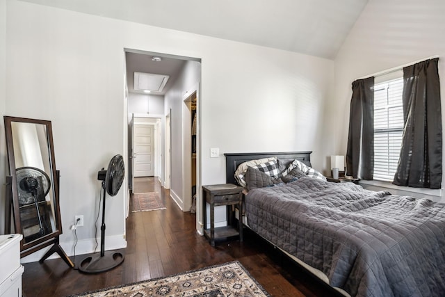 bedroom featuring hardwood / wood-style flooring, vaulted ceiling, baseboards, and attic access