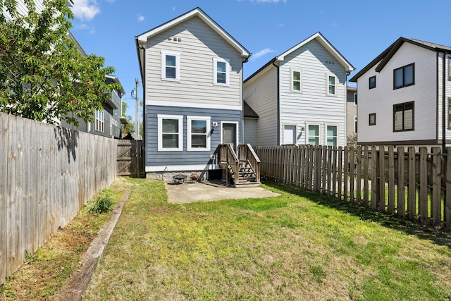 rear view of property featuring a fenced backyard, a yard, and a patio