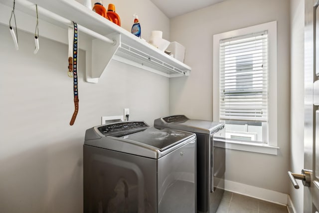 laundry area featuring light tile patterned flooring, independent washer and dryer, baseboards, and laundry area
