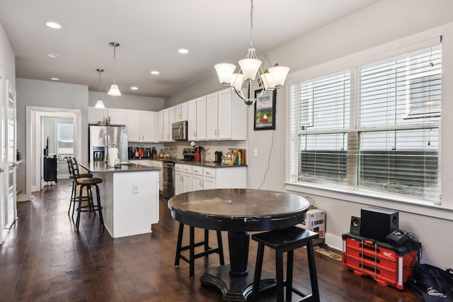 dining area with dark wood-type flooring, baseboards, recessed lighting, and a notable chandelier