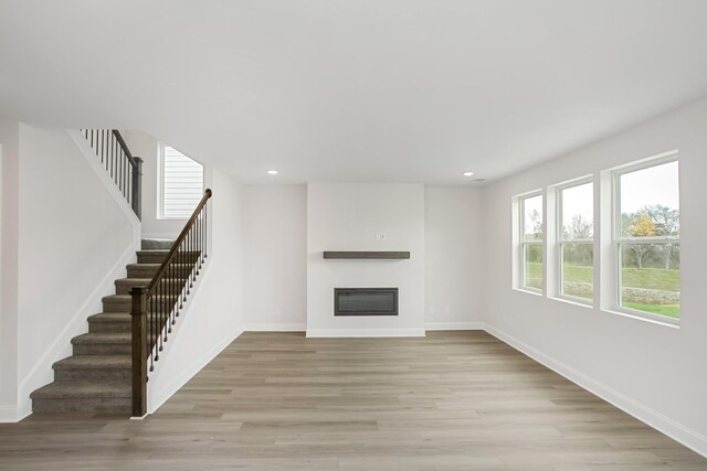 1714 Allwood Ave E, Murfreesboro, TN 37128 - unfurnished living room with baseboards, light wood-style floors, recessed lighting, stairs, and a glass covered fireplace