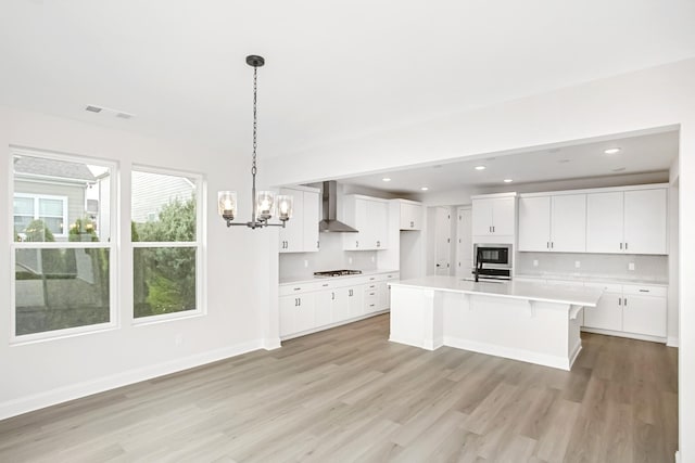 1714 Allwood Ave E, Murfreesboro, TN 37128 - kitchen with light wood-style floors, wall chimney exhaust hood, light countertops, cooktop, and a notable chandelier