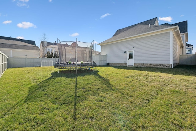 view of yard featuring a trampoline and a fenced backyard
