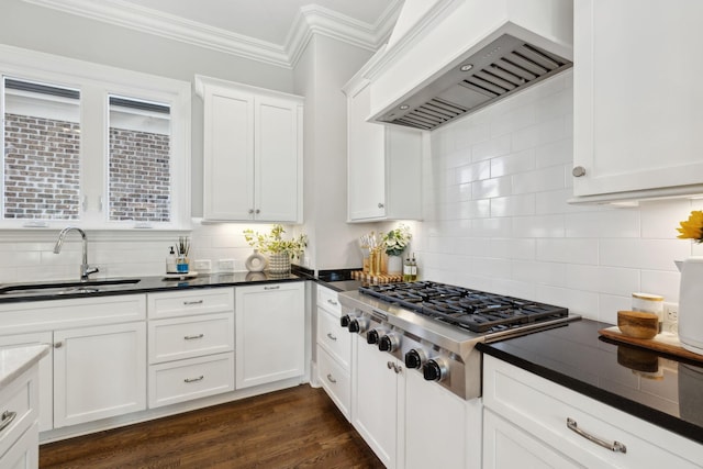 kitchen featuring custom exhaust hood, a sink, crown molding, dark wood-type flooring, and stainless steel gas cooktop