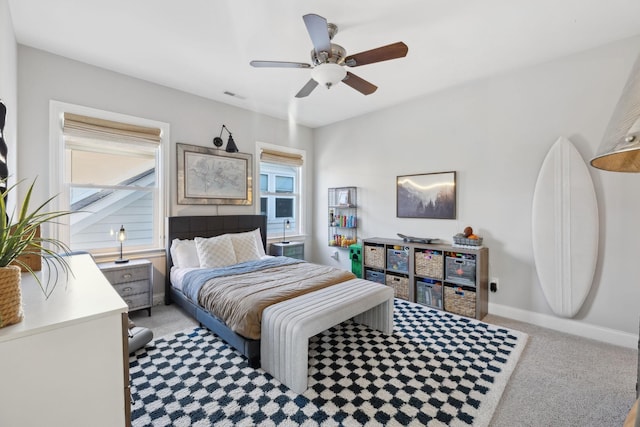 carpeted bedroom with visible vents, baseboards, and a ceiling fan