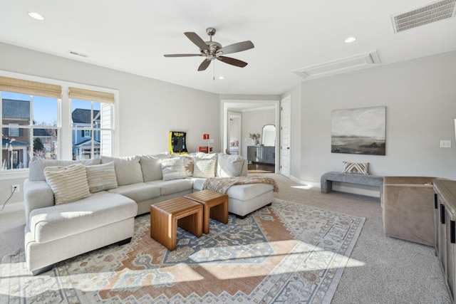 living room with a ceiling fan, attic access, carpet flooring, and visible vents